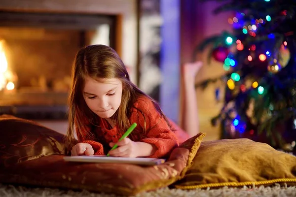 Küçük kız Noel Baba'ya bir mektup yazma — Stok fotoğraf