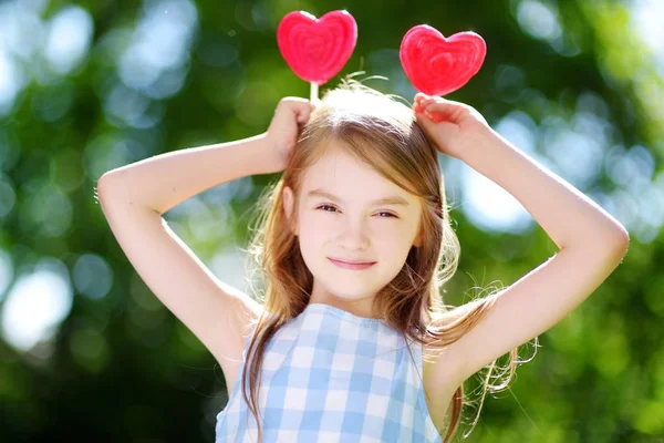 Menina com pirulitos em forma de coração — Fotografia de Stock