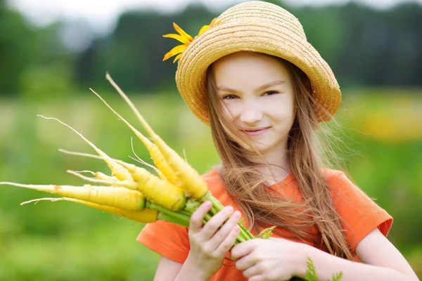 Chica sosteniendo un montón de zanahorias — Foto de Stock