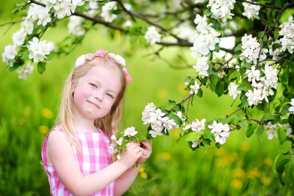 Liten flicka i blommande trädgård — Stockfoto