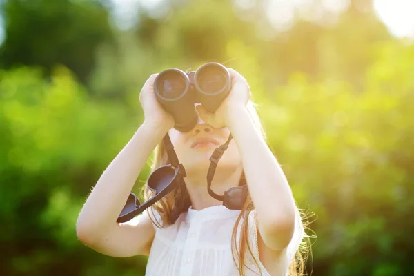 Niña mirando a través de los prismáticos — Foto de Stock