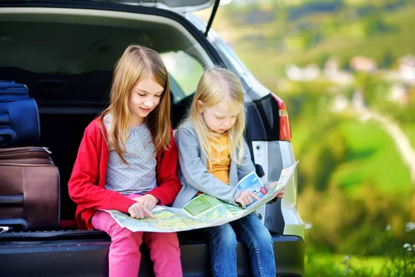 Two little sisters exploring a map — Stock Photo, Image