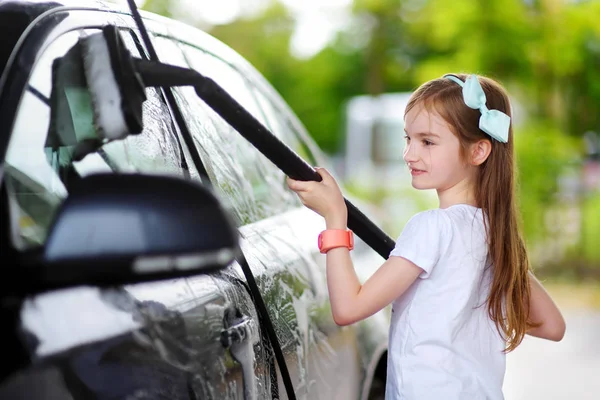 Adorable little girl washing car — Stock Photo, Image