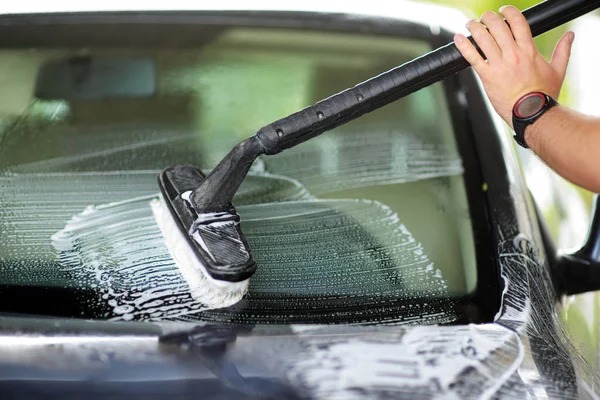 Использование щетки для мытья автомобиля — стоковое фото