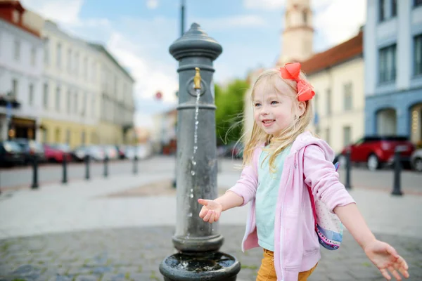 Tjej att ha kul med dricksvattenfontän — Stockfoto