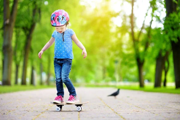 Pretty girl learning to skateboard — Stock Photo, Image