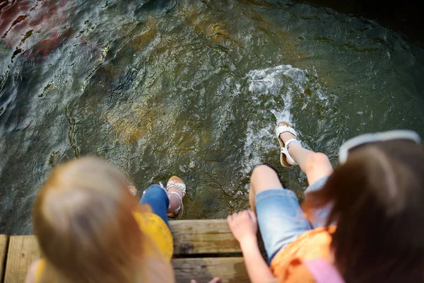 Meisjes zitten door de rivier — Stockfoto