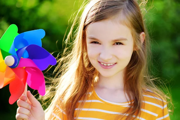 Meisje houdt van kleurrijke speelgoed pinwheel — Stockfoto