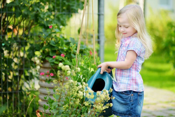 Bonito menina regando flores — Fotografia de Stock