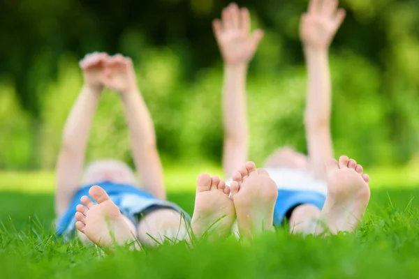 Deux enfants pieds sur l'herbe à l'extérieur — Photo