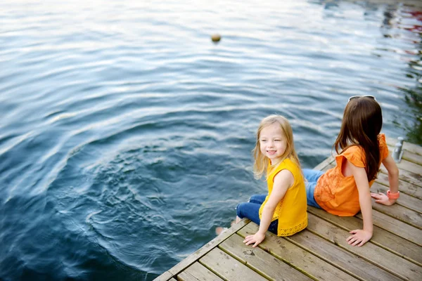 Petites filles assis près de la rivière — Photo