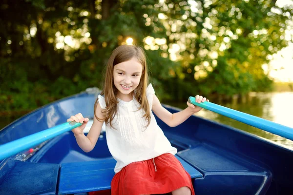 Niña divirtiéndose en un barco junto a un río — Foto de Stock