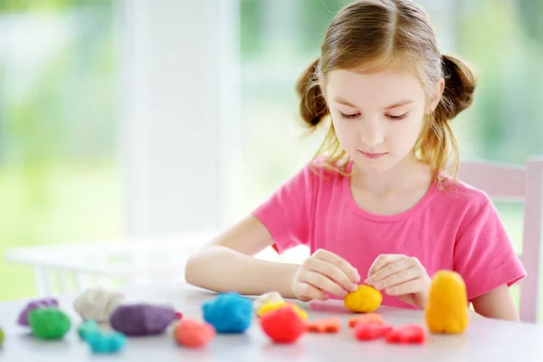 Meisje met kleurrijke modellering klei — Stockfoto