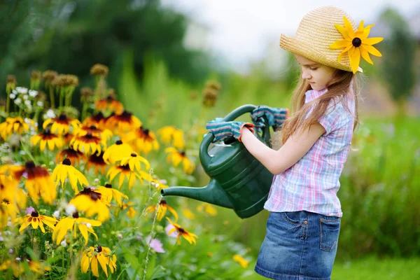 Bahçede çiçekleri sulayan kız. — Stok fotoğraf