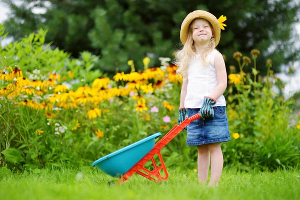 Girl having fun with a toy wheelbarrow — Stock Photo, Image