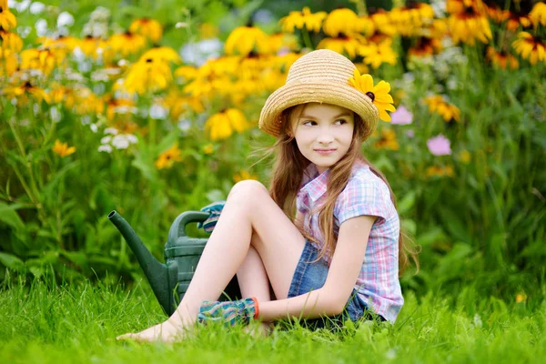 Roztomilá malá holka zalévání květin — Stock fotografie