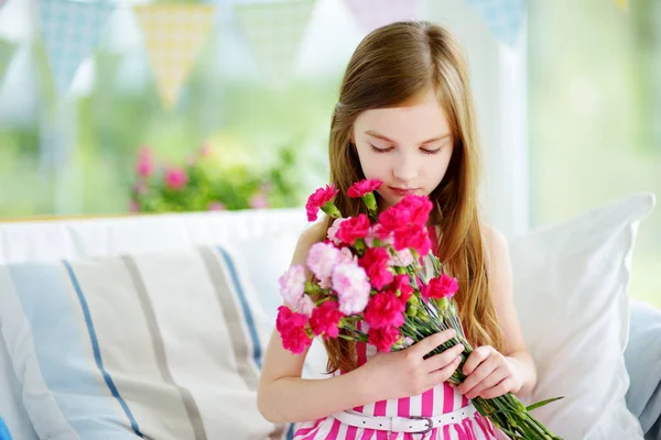 Sorrindo menina segurando flores — Fotografia de Stock