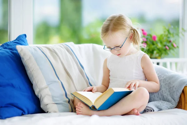 Κοπέλα φορώντας γυαλιά διαβάζοντας ένα βιβλίο — Φωτογραφία Αρχείου