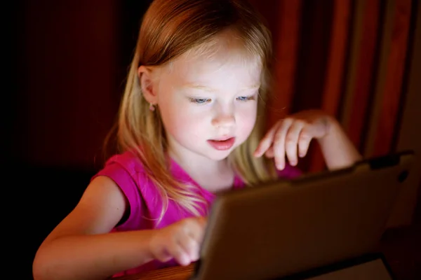 Entzückendes Mädchen spielt mit einem digitalen Tablet — Stockfoto