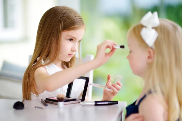 Two cute funny sisters applying make-up — Stock Photo, Image
