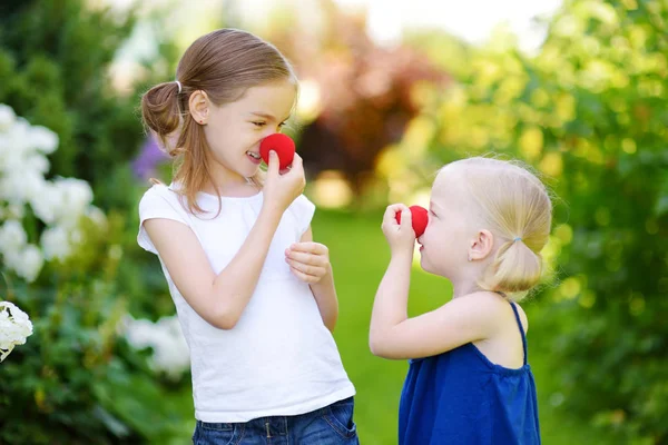 Systrar som bär röd clown näsor — Stockfoto