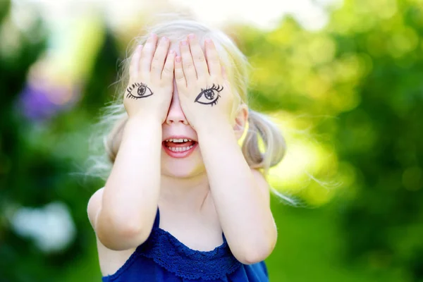 Schattig klein meisje die betrekking hebben op haar gezicht met haar handen — Stockfoto