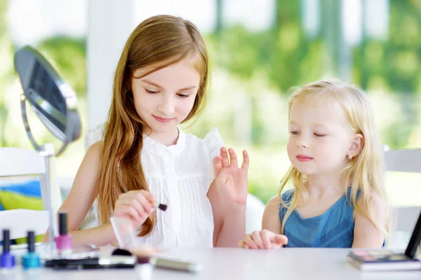 Dos hermanas graciosas lindas aplicando maquillaje — Foto de Stock