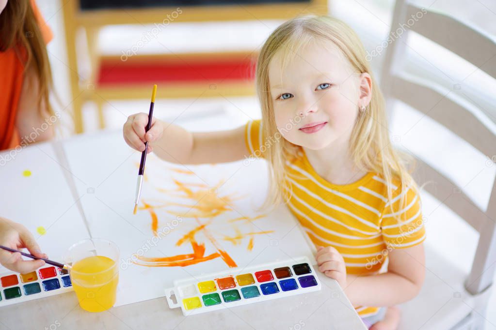 little girl drawing with colorful paints 