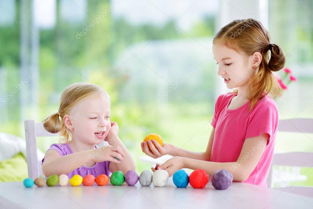 sisters  with colorful modeling clay  