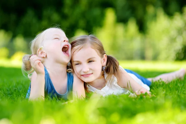 Сестры веселятся вместе на траве — стоковое фото