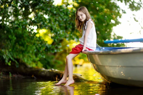 Menina se divertindo em um barco perto de um rio — Fotografia de Stock