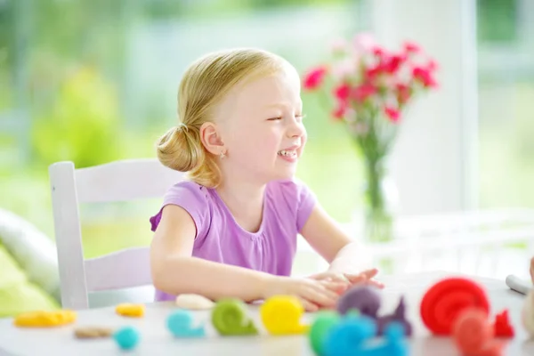 Милая маленькая девочка играет с пластилином — стоковое фото