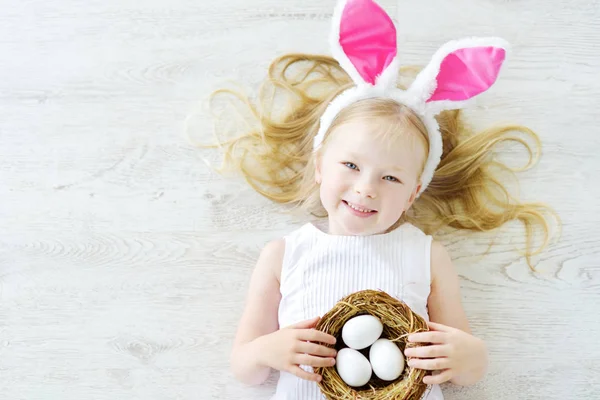 Girl wearing bunny ears playing eggs — Stock Photo, Image