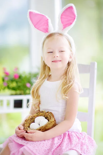 Girl wearing bunny ears playing eggs — Stock Photo, Image