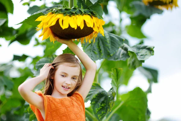 Ragazza che raggiunge per girasole — Foto Stock