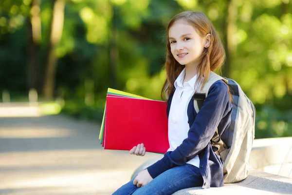 Liten skolflicka med böcker — Stockfoto