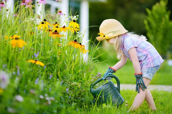 Девушка поливает цветы — стоковое фото