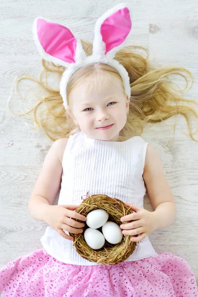 Chica con huevos blancos en el suelo — Foto de Stock