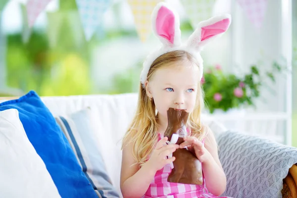 Meisje eten chocolade konijn — Stockfoto