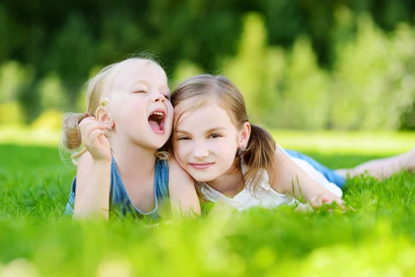 Sisters lying together on grass — Stock Photo, Image
