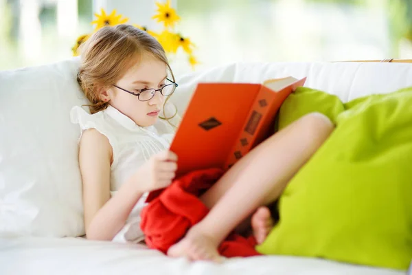 Menina vestindo óculos leitura livro — Fotografia de Stock