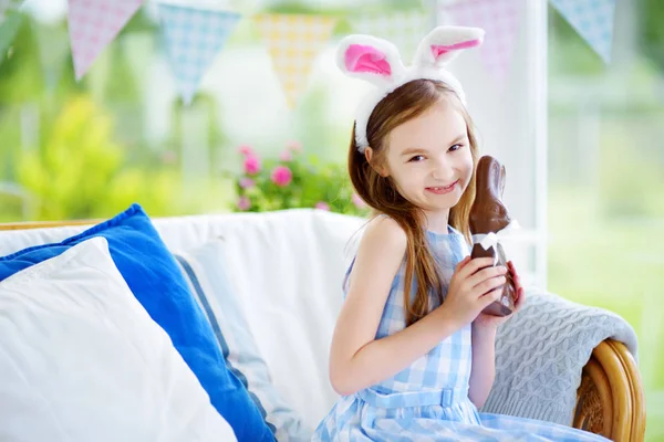 Chica comer chocolate conejo — Foto de Stock