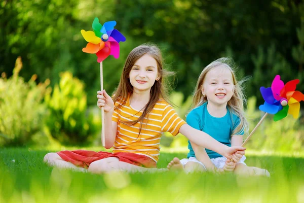 Κορίτσια κρατώντας pinwheels παιχνίδι — Φωτογραφία Αρχείου