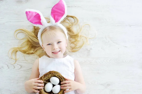 Chica con huevos blancos en el suelo — Foto de Stock