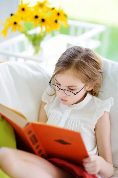 Chica vistiendo anteojos leer libro —  Fotos de Stock