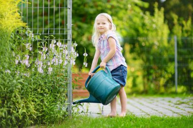 sevimli küçük kız sulama çiçekler 