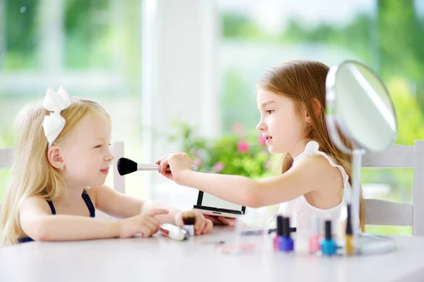 Dos hermanas aplicando maquillaje — Foto de Stock