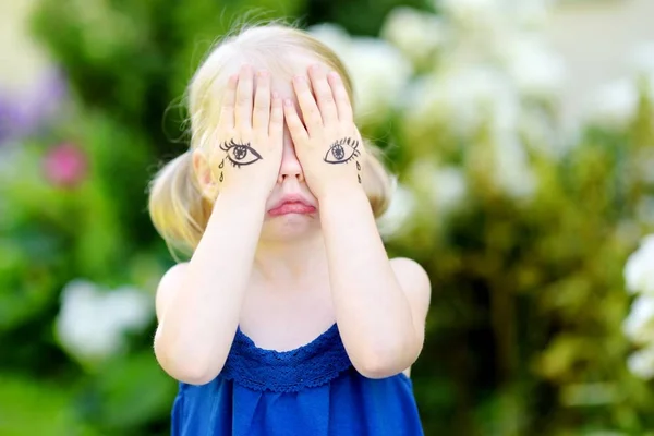 Klein meisje die betrekking hebben op gezicht met handen — Stockfoto
