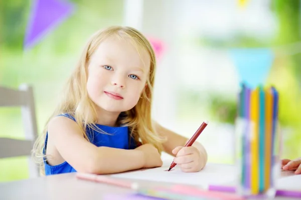 Милая маленькая девочка рисует карандашами — стоковое фото