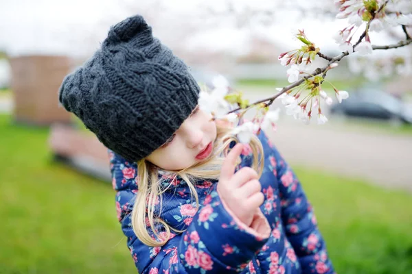 Malá dívka baví v rozkvetlé zahradě — Stock fotografie